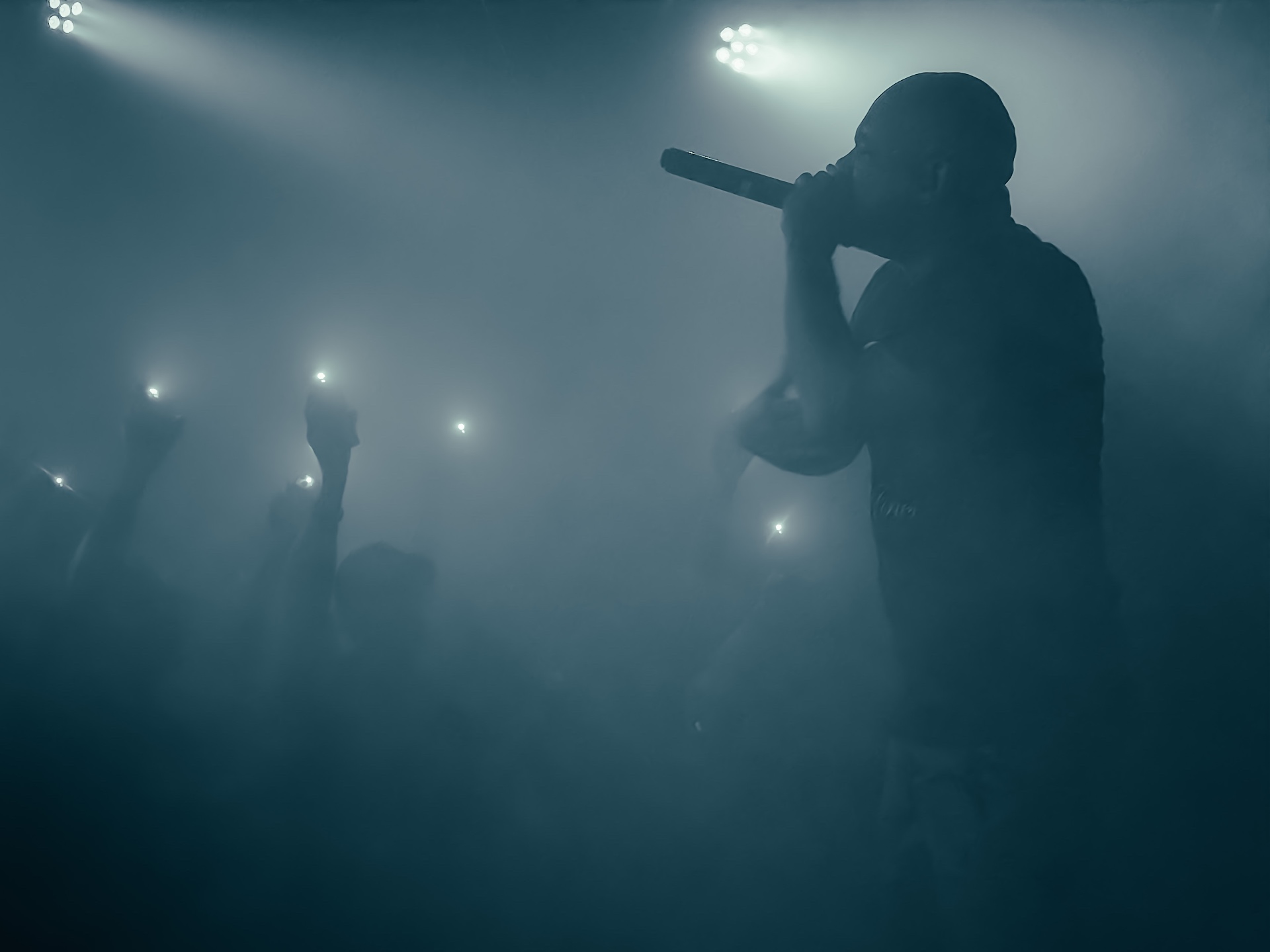 Vocalist emerging through stage fog