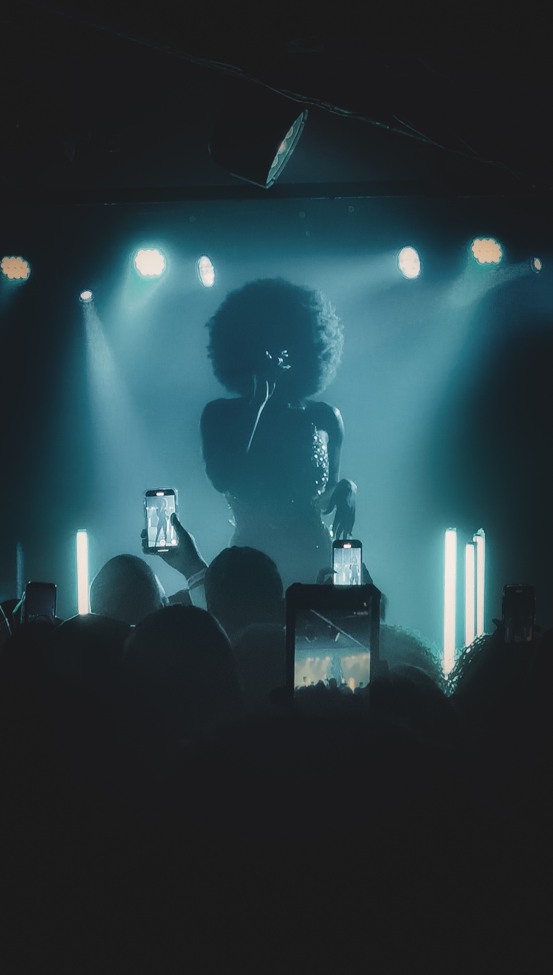 Audience phones lifted toward the stage